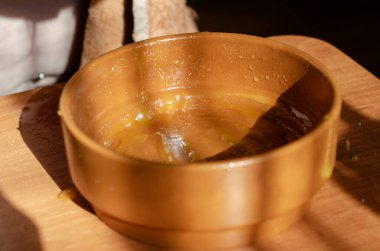 Yakından bal kalıntıları olan kahverengi kil kase. Sarı bal damlalarıyla dolu boş yuvarlak kase. Seçici odak.