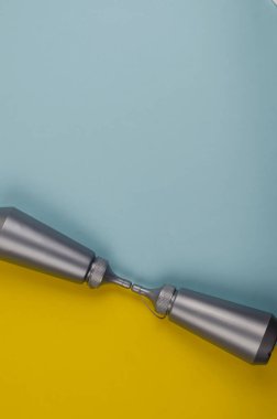 Sarı ve mavi arka planda iki gri plastik şişe. Sos ve sos şişesi. Düz yatıyordu. Boşluğu kopyala