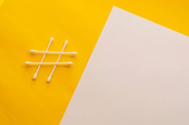 Beyaz ve sarı arka planda etiket şeklinde pamuklu çubuklar. Kopyalama alanı olan minimalist kavramsal arkaplan.