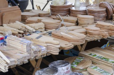 Mutfak için ahşap ürünlerle dolu sokak tezgahı. Kesme tahtaları, merdaneler, ızgaralar ve doğal ahşaptan yapılmış diğer mutfak aletleri. Ukraynaca isimleri olan yazıtlar. Nikolaev, Ukrayna - 10 Mart 2021.