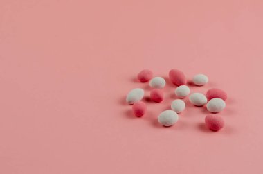 Pembe arka planda Tatlı Dragee. Şeker jölesiyle kaplı fıstıklar. Yakın plan, seçici odaklanma. Boşluğu kopyala