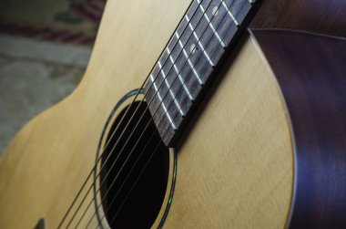 Akustik altı telli gitar parçası. Telli sarı gitar. İçeride. Yakın plan. Seçici odak.