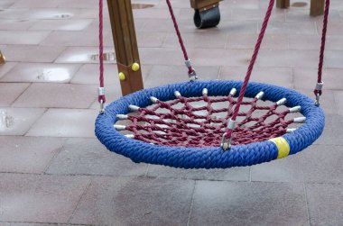 Yağmurdan sonra boş çocuk parkı. Su birikintilerinin arasında ıslak salıncak. Hava, yağış.