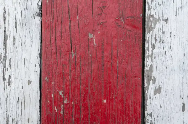 Three old wooden boards with cracked paint. Weathered white and red boards. Cracked wood texture. Abstract background.