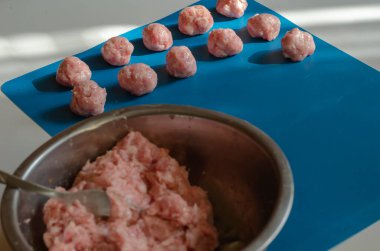 Çiğ köfte ve kıymalı metal kase ve çatalla mavi. Arka planda biberli, tuzlu ve baharatlı köfteler. Arkaplana odaklan