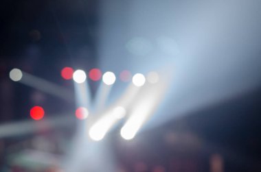 Bir müzik konseri sırasında sahne ışığı ile odaklanmış soyut kompozisyon. Karanlıkta ışıldayan projektörler. Bulanık, gürültü, yumuşak odaklanma.