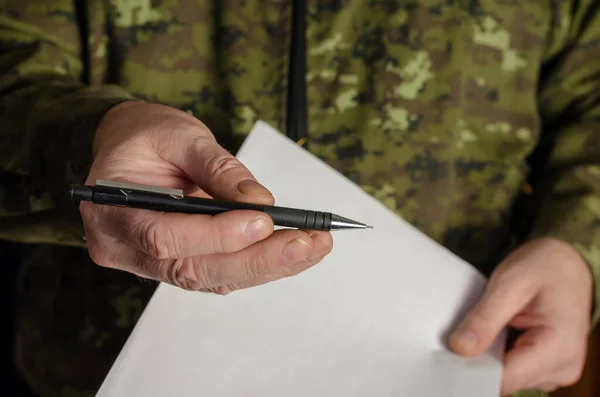 Bir memur kameraya siyah bir kalem uzatıyor. Bir adamın eli belge imzalamak için bir kalem sunar. Yetişkin, orta yaşlı bir adam. Seçici Odaklanma. Alçakgönüllülük. Kapalı.