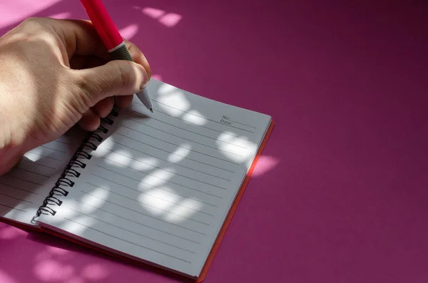 Composición Clara Sombreada Escritura Mano Izquierda Cuaderno Sobre Fondo Rosa — Foto de Stock