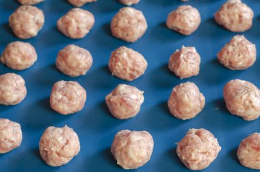 Çiğ şekilli köfteler. Biberli, tuzlu ve baharatlı köfteler. Bir açıdan yan görüş. Ön odak