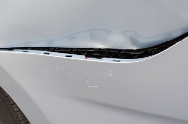 Trafik kazası oldu. Hasarlı arka çamurluğa ve gri bir sedanın tamponuna yakından bakın. Tampon parçaları kopmuş ve araba gövdesinde göçükler var. Aracın sol arka tarafında. Otomatik Sigorta