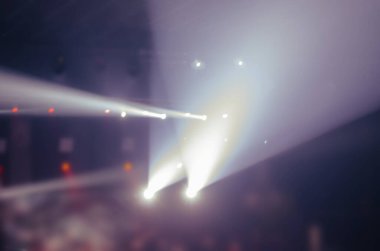 Bir müzik konseri sırasında sahne ışığı ile odaklanmış soyut kompozisyon. Karanlıkta ışıldayan projektörler. Bulanık, gürültü, yumuşak odaklanma.