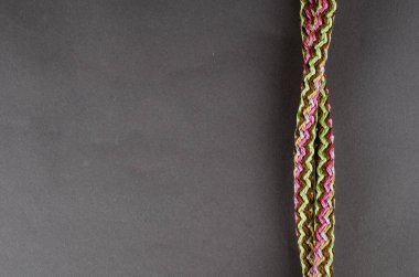 Gri arka planda çok yönlü propilen ip. Yuvarlak renkli örülmüş sentetik iplik, çekirdekli. Üst Manzara, düz çizgi. Boşluğu kopyala.