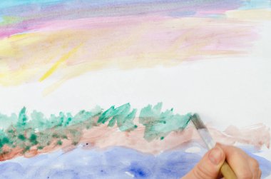 Çizim yapmayı öğrenmek, hobiler. Kağıda bir resim çiz. Beşinci adım: çimleri boya. Fırçalı kadın kahverengi üzerine yeşil sürüyor. Bir fırçayla elin bulanık hareketi.