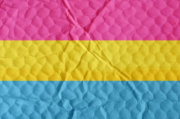 Pansexual pride flag on an uneven textured surface. Concept of love, equality, freedom of choice, unity in diversity, beauty and joy.
