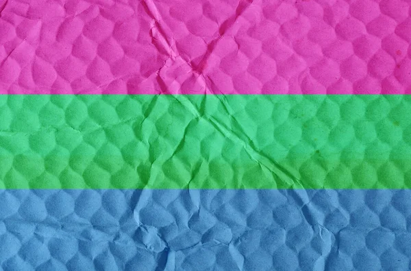 Polysexual pride flag on an uneven textured surface. Concept of love, equality, freedom of choice, unity in diversity, beauty and joy.