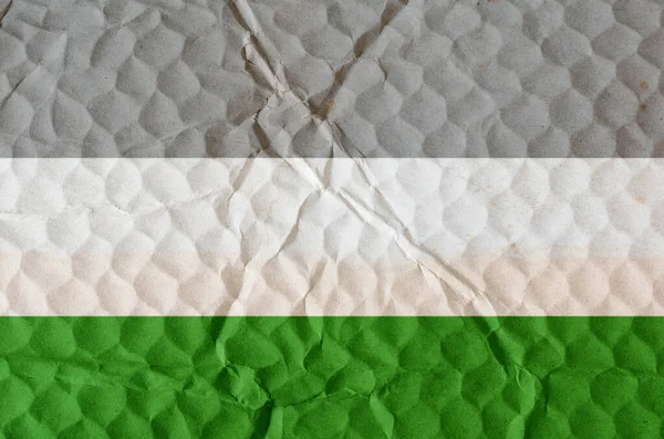 Three-color naturist flag on uneven textured surface. Concept of love, equality, freedom of choice, unity in diversity, beauty and joy.