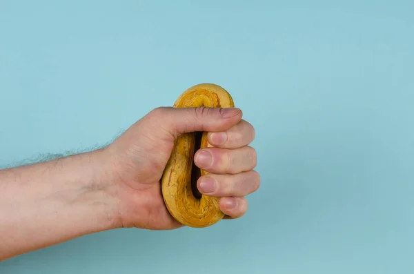 Mão Está Segurando Elástico Amarelo Fundo Azul Homem Adulto Segurando — Fotografia de Stock