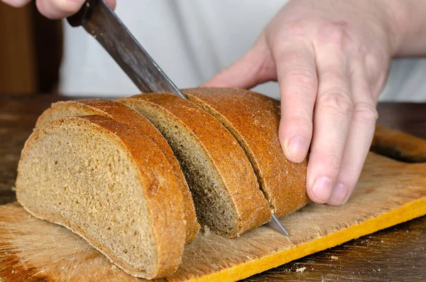 Ręce Kroją Chleb Drewnianej Desce Krojenia Dorosły Mężczyzna Kroi Bochenek — Zdjęcie stockowe