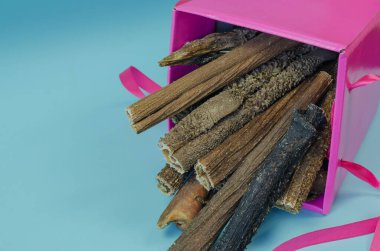 Mavi arka planda bir kutu ödül. Yavru köpekler, yetişkin köpekler ve yaşlı köpekler için kurutulmuş diş malzemesi. Lezzetli Sığır Budu Midesi. Sığır üçlüsü. Hediye kutusu..