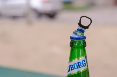 Bir bira Tuborg Green ve yakın çekim. Meşhur bira şişesinden bir şişe. Açık havada. Nikolaev, Ukrayna - 16 Nisan 2021