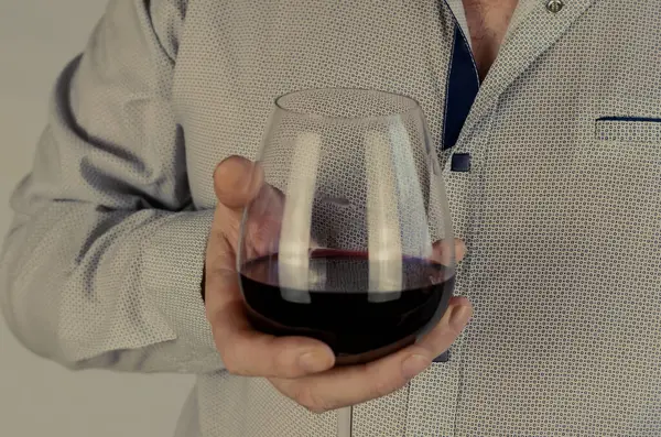 成年男子拿着一个装有红葡萄酒的酒杯 胸部水平 有选择的重点 彩色照片 — 图库照片
