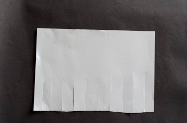Gri arka planda yırtık sekmeleri olan beyaz, boş bir kağıt. Düzensiz çizgileri olan buruşuk bir kağıt parçası. Yırtık kitap ayracı. Yeni ya da ilginç olmayan reklam kavramı.