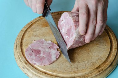 El yapımı ev yapımı, sarımsaklı, tuzlu ve karabiberli jambon. Ahşap bir kesme tahtasının üzerinde kaplama olmadan domuz jambonu yemek. Ev yapımı hazır yemek..