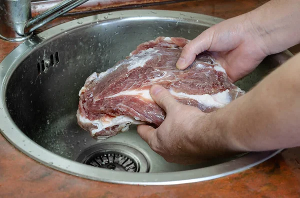 自家製カピコラ コッパ 乾燥した豚ロースのステップバイステップのレシピ 男は豚肉を塩で洗います 彼の手は水の下で流しの中でマリネ肉を保持します 伝統的なイタリア料理 — ストック写真