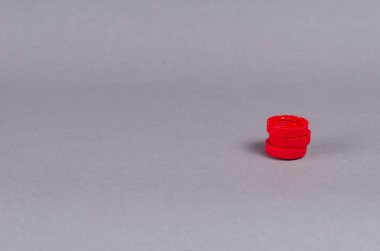 Kırmızı şişe önleyiciler arka planda. Üç plastik meşrubat durduruculu minimalist kompozisyon.