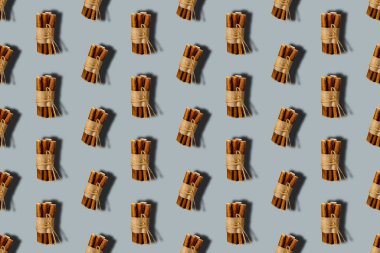 Gri arka planda tekrarlanabilir evcil hayvan muamelesi. Kağıt ve sicimle sarılı köpekler için kurutulmuş kabadayı sopaları..