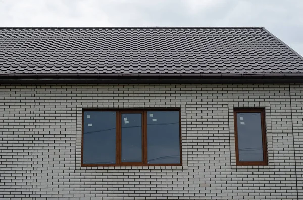 Beyaz Tuğlalı Duvardaki Kahverengi Pencereler Kahverengi Bir Çatı Altında Yeni — Stok fotoğraf