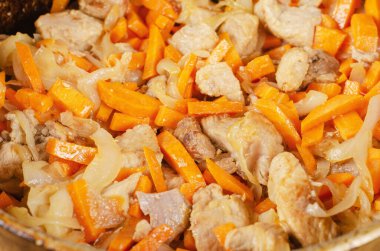 Kazanda sebzeli et var. Soğan ve havuçla karıştırılmış domuz eti parçaları. Yemek pilavı. Ev yemeği konsepti.