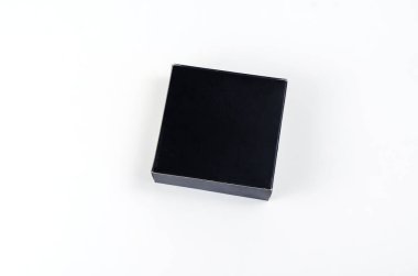 Beyaz arka planda küçük kare siyah hediye kutusu. Romantik hediyeleri veya mücevherleri paketlemek için karton kutu..