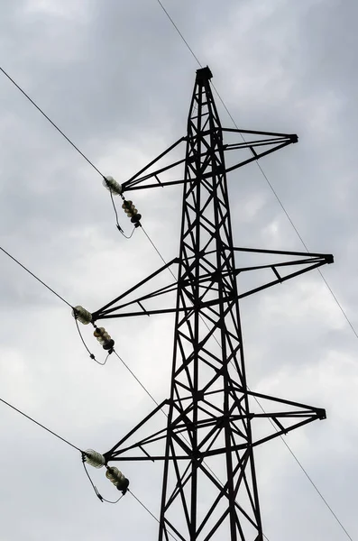 Ein Hochspannungsmast Aus Metall Vor Einem Grauen Bewölkten Himmel Der — Stockfoto