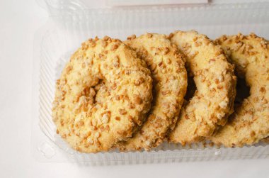 Şeffaf plastik bir kutuda Peanut Bisküvi Halkaları 'nın yakın çekimi. Fındıklı çıtır lezzetli kurabiyeler..