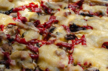 Ev yapımı bir pizza tepsisinin yakın çekimi. Salam, hindi, mantar, domates, sos, peynir. Yemek hazır..