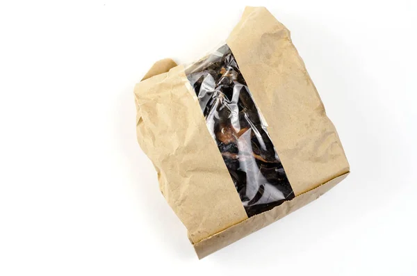ペットは窓のある茶色の紙袋で扱う 白い背景に乾燥牛肉腎臓の部分が付いている1つのクラフトバッグ 犬に便利なお菓子 — ストック写真