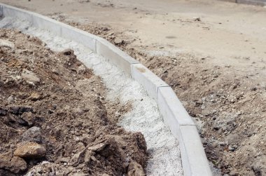 Yeni kaldırımlar kuruluyor. Gri kaldırımlar beton harca sabitlenmiş. Yeni bir yol inşaatı ya da eski bir yolun onarımı. Endüstri. Dışarı çıkın. Gündüz vakti. Kimse yok..