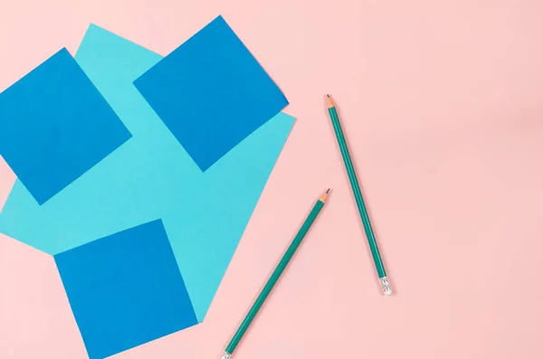 분홍빛 배경에는 종이와 연필이 사각형 파란색 과밝은 파란색 지우개 위에서 — 스톡 사진
