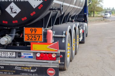 Tanker kamyonunun arkasında. Kamyon yolun kenarında dikiliyordu. Uyarı yazıları, tehlike ve zehirlenme işaretleri. Ticari araç. Nikolaev, Ukrayna - 08 19 2021