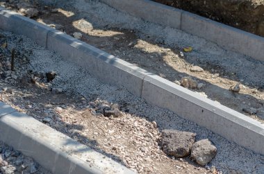 Yeni bir yol, kaldırım, kanalizasyon inşaatı. Yaya geçidi ve garaj yolu yeni kaldırımlarla çevrili. Tamir ve inşaat işleri. Dışarı çıkın. Seçici odaklanma. Kimse yok..