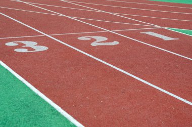 Koşu pistindeki rakamlar 1,2,3. Stadyumda kırmızı koşu pistleri. Spor, aktif yaşam tarzı. Seçici dikkat.