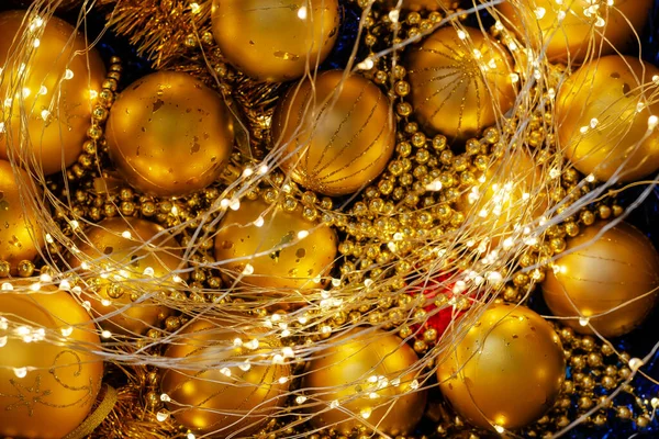 Sprankelende gouden kerstversieringen. Gildeverlichting, kerstversiering — Stockfoto