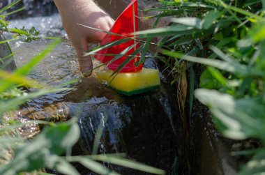 Bir adam çocuk teknesini dar bir kanala ya da dereye indiriyor. Bir sma
