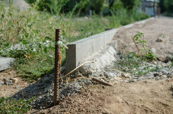 Uma barra de vergalhões verticalmente com uma corda amarrada na construção s — Fotografia de Stock