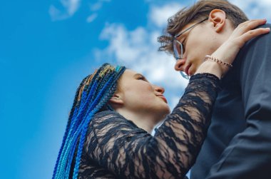 Mavi bir gökyüzüne karşı aşık bir çift. Bla 'lı genç bir adam