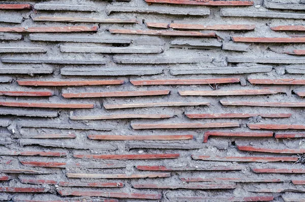 Çimentolu kırmızı kiremitlerden bir duvar. Çamur kiremitleri yatay — Stok fotoğraf