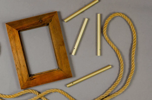 Empty photo frame and rope against a gray background. Wooden pic — Stock Photo, Image