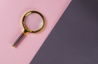 Gri-pembe arka planda bir büyüteç. Minimalist kompozi