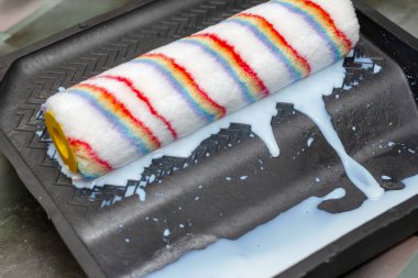 Boya silindiri plastik bir tepside sıkışıyor. Duvar önü...